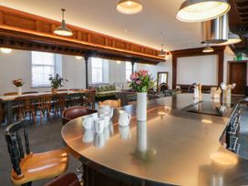 A kitchen with a bar counter and dining table at Capel Llani in Llanidloes
