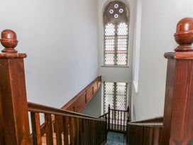 A staircase with wooden handrails and stained glass windows at Capel Llani Llanidloes