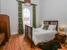 A bedroom with a bed and wardrobe at Capel Llani in Llanidloes