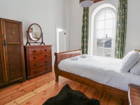 A bedroom with a bed and wardrobe at Capel Llani in Llanidloes