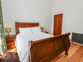 A bedroom with a wooden bed and side tables at Capel Llani Llanidloes