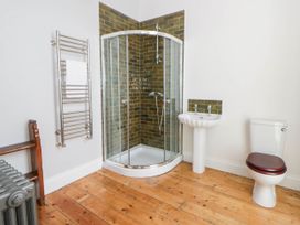 A bathroom with a shower, sink and toilet at Capel Llani in Llanidloes
