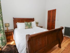 A bedroom with a wooden bed and bedside tables at Capel Llani in Llanidloes
