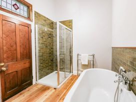 A bathroom with a shower and bathtub at Capel Llani in Llanidloes