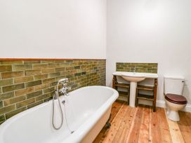 A bathroom with a bathtub, sink, and toilet at Capel Llani in Llanidloes