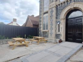 An outdoor area with tables and benches at Capel Llani Llanidloes