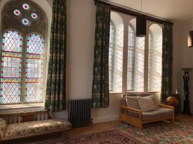 A living room with stained glass windows and a sofa at Capel Llani in Llanidloes