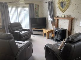 A living room with recliner chairs and a television at Ivy Corner