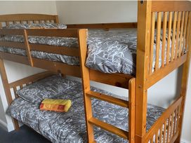 A bunk bed with gray bedding at Ivy Corner