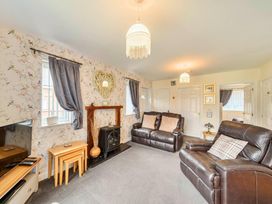 A living room with a sofa and television at Ivy Corner in Bridlington
