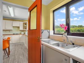 A kitchen with cabinets and a sink visible through an open door at the property in location