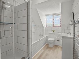 A bathroom with a shower, bathtub, toilet, and sink at The Old Barn in Manchester