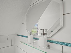 A bathroom with a mirror and soap dispenser on a shelf.