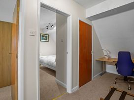 A bedroom with a desk and chair visible at a property in 