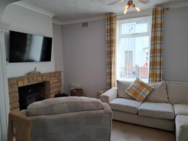 A living room with a sofa and television at Fisherman's Cottage