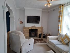 A living room with an armchair and a television at Fisherman's Cottage