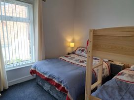 A bedroom with a bunk bed and a window at Fisherman's Cottage