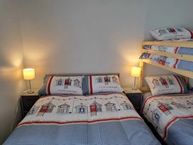 A bedroom with a double bed and bunk bed at Fisherman's Cottage