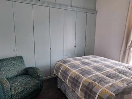 A bedroom with a bed and wardrobe at Fisherman's Cottage in 
