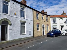 A street with several buildings and parked cars at Fisherman's Cottage
