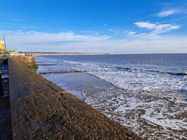 A coastal view with waves and a pier at Fisherman's Cottage in 