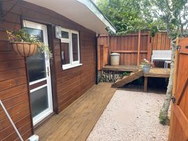 A garden with wooden deck and storage container at Little Russets in 