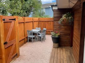 A garden with a table and chairs surrounded by a wooden fence at Little Russets 
