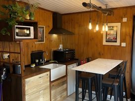 A kitchen with a wooden wall and modern appliances at Little Russets