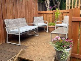 A garden seating area with sofas and a table at Little Russets
