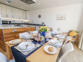 A dining room with a table set for a meal at Sea Fern House - 36 Poole