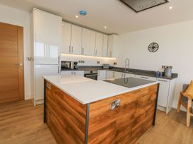 A kitchen with cabinets and an island at Sea Fern House - 36 Poole