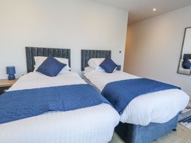 A bedroom with two beds and a bedside table at Sea Fern House - 36 Poole