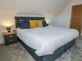 A bedroom with a bed and nightstand at Sea Fern House - 36 in Poole