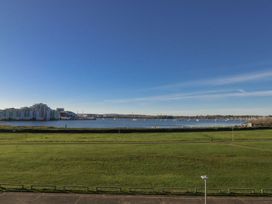 A view of water with boats and grass at Sea Fern House - 36 Poole