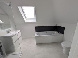 A bathroom with a bathtub and a sink at Sea Fern House - 36 in Poole