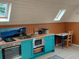 A kitchen with a stove, sink, microwave, and table at The Old Barn in Manchester