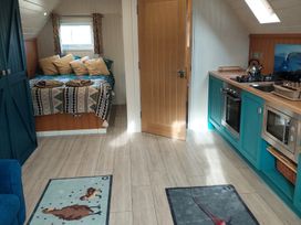 A living room with a bed and kitchen area at The Hideaway in Unknown