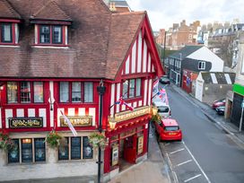 A pub with a red and white exterior on a street at Red Rose Apartment 