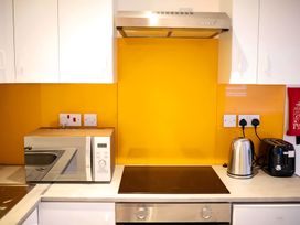 A kitchen with a microwave and kettle at Red Rose Apartment