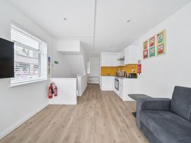 A kitchen area with a sofa and appliances at Red Rose Apartment in Weymouth