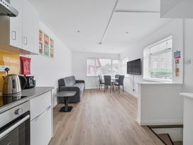 A kitchen with a dining area and a television at Red Rose Apartment in Weymouth