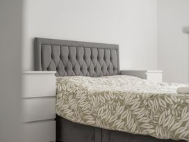 A bedroom with a bed and nightstands at Red Rose Apartment in Weymouth