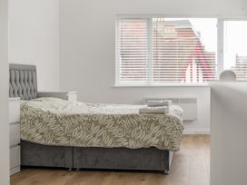 A bedroom with a bed and window at Red Rose Apartment in Weymouth