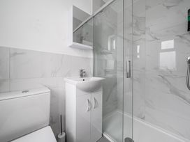 A bathroom with a shower, sink, and toilet at Red Rose Apartment in Weymouth