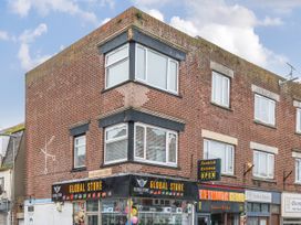 A building with a store and windows at Red Rose Apartment Weymouth