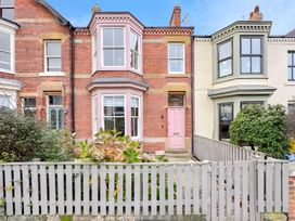 A house exterior featuring brick walls and a pink front door at Victorian Beach House