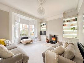A living room with a fireplace and shelves at Victorian Beach House