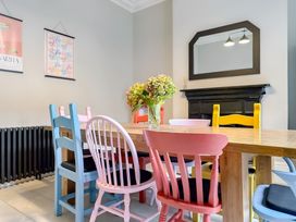 A dining room with a table and colorful chairs at Victorian Beach House