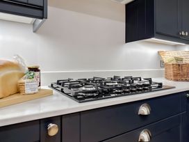 A kitchen with stove, bread, jar and basket at Victorian Beach House