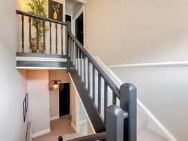 A staircase with a plant and wall art in a hallway at Victorian Beach House